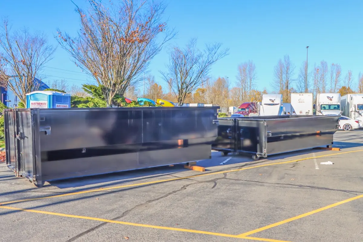 Professional dumpster rental service with roll-off container on residential driveway in Daleville